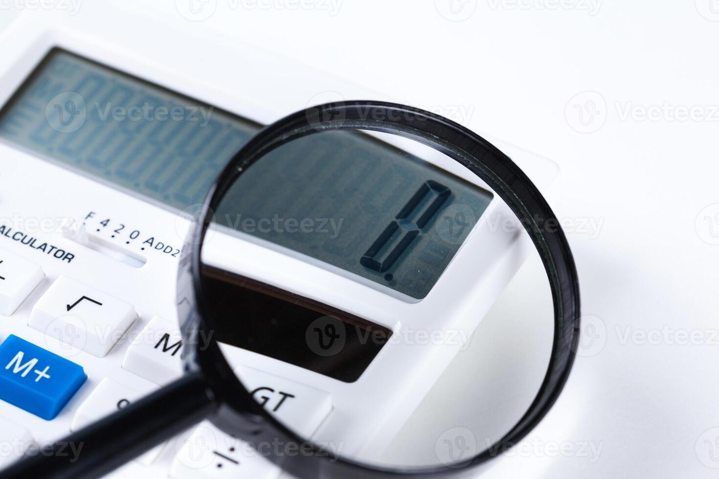 Calculator with a magnifying glass on a white background photo