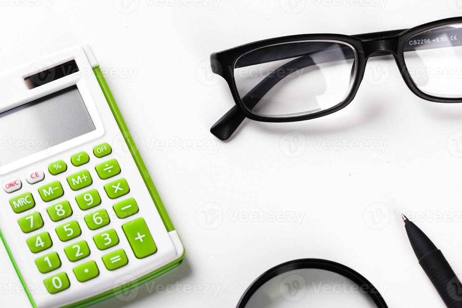 Calculator with a magnifying glass on a white background photo