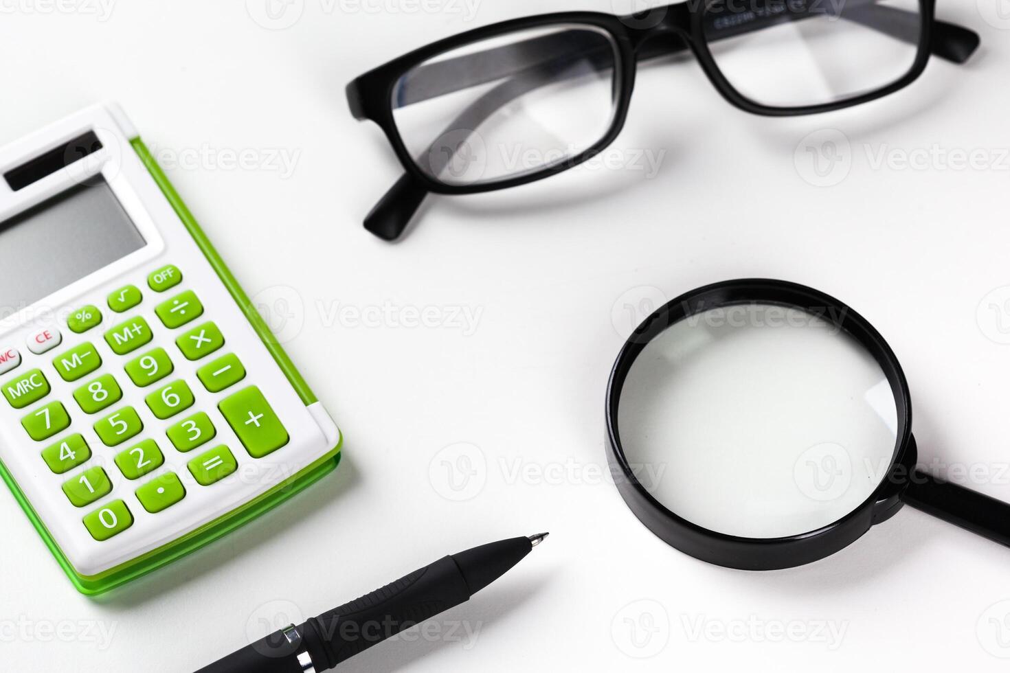 Calculator with a magnifying glass on a white background photo