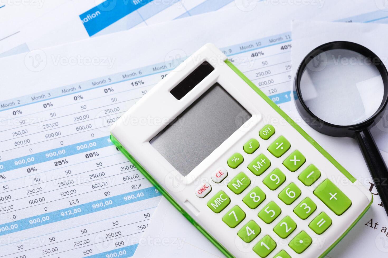 work with a magnifying glass, a calculator and papers photo
