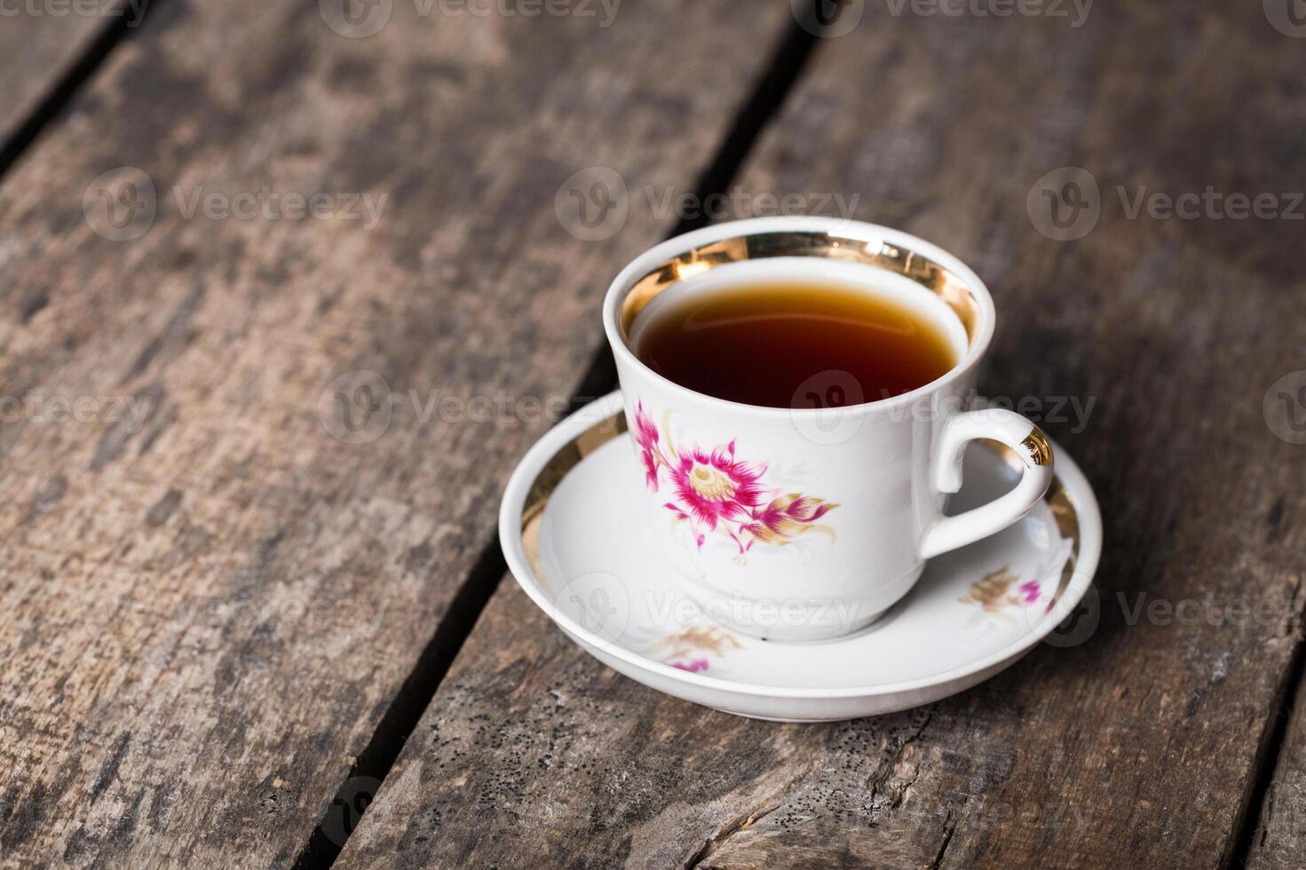Closeup of cup of tea on vintage wooden background photo