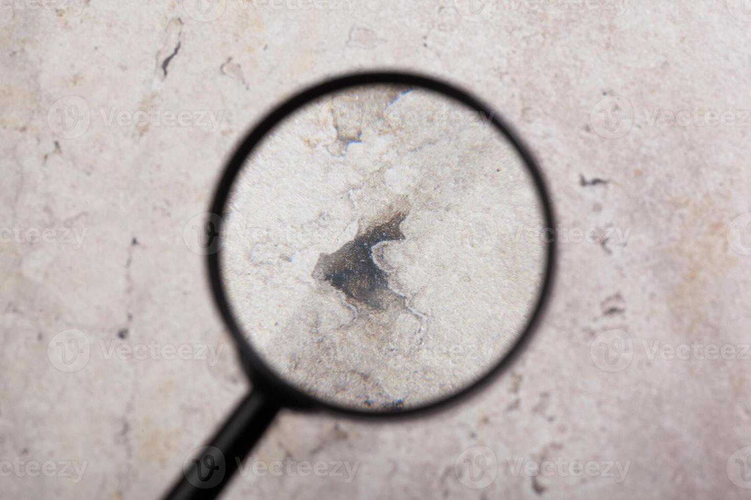 Magnifying glass with empty stone background. photo