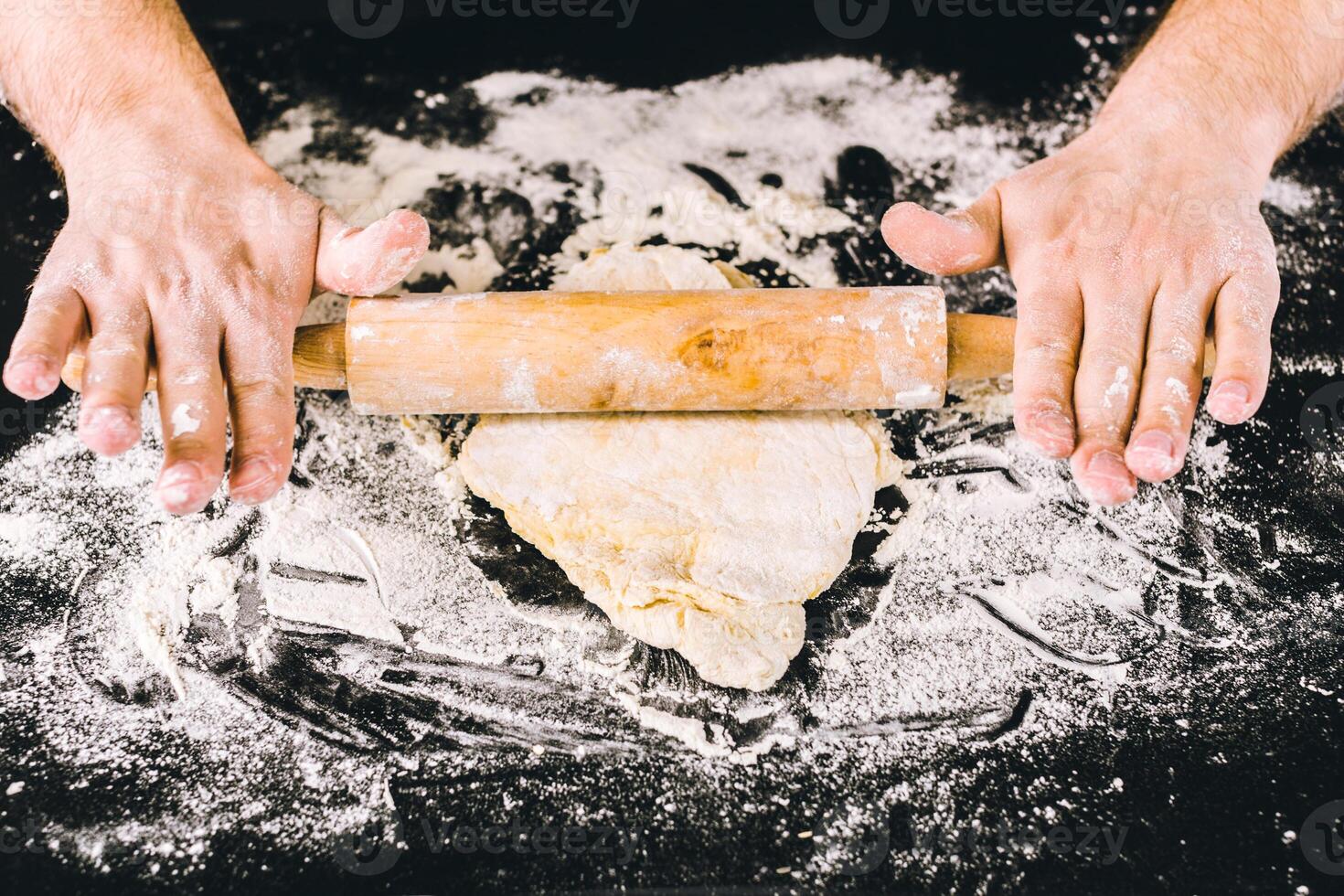 Hands baking dough with rolling pin photo