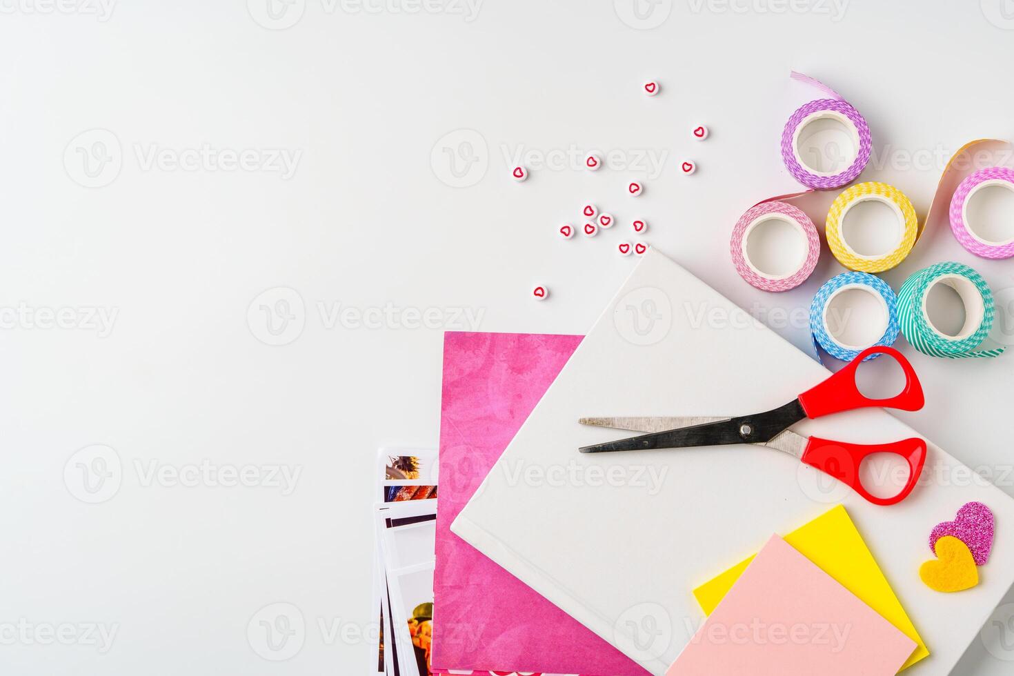 Creative crafting setup with scissors, colored paper, and decorative tape on a white background photo