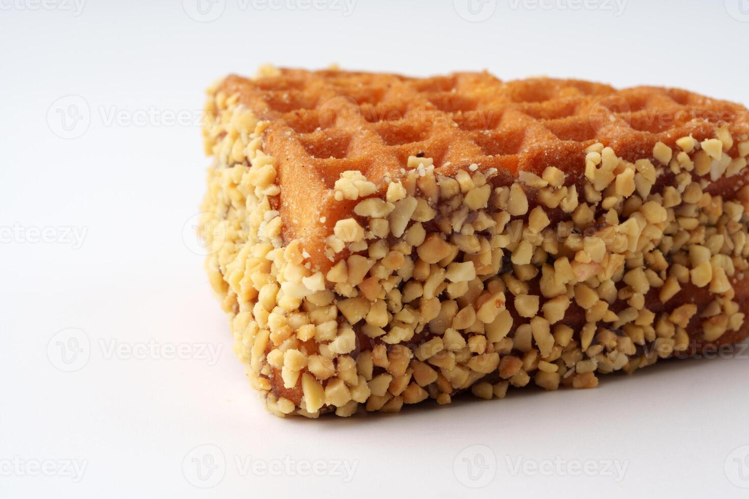 Delicious triangular waffle coated with crushed nuts ready to be enjoyed as a sweet treat photo