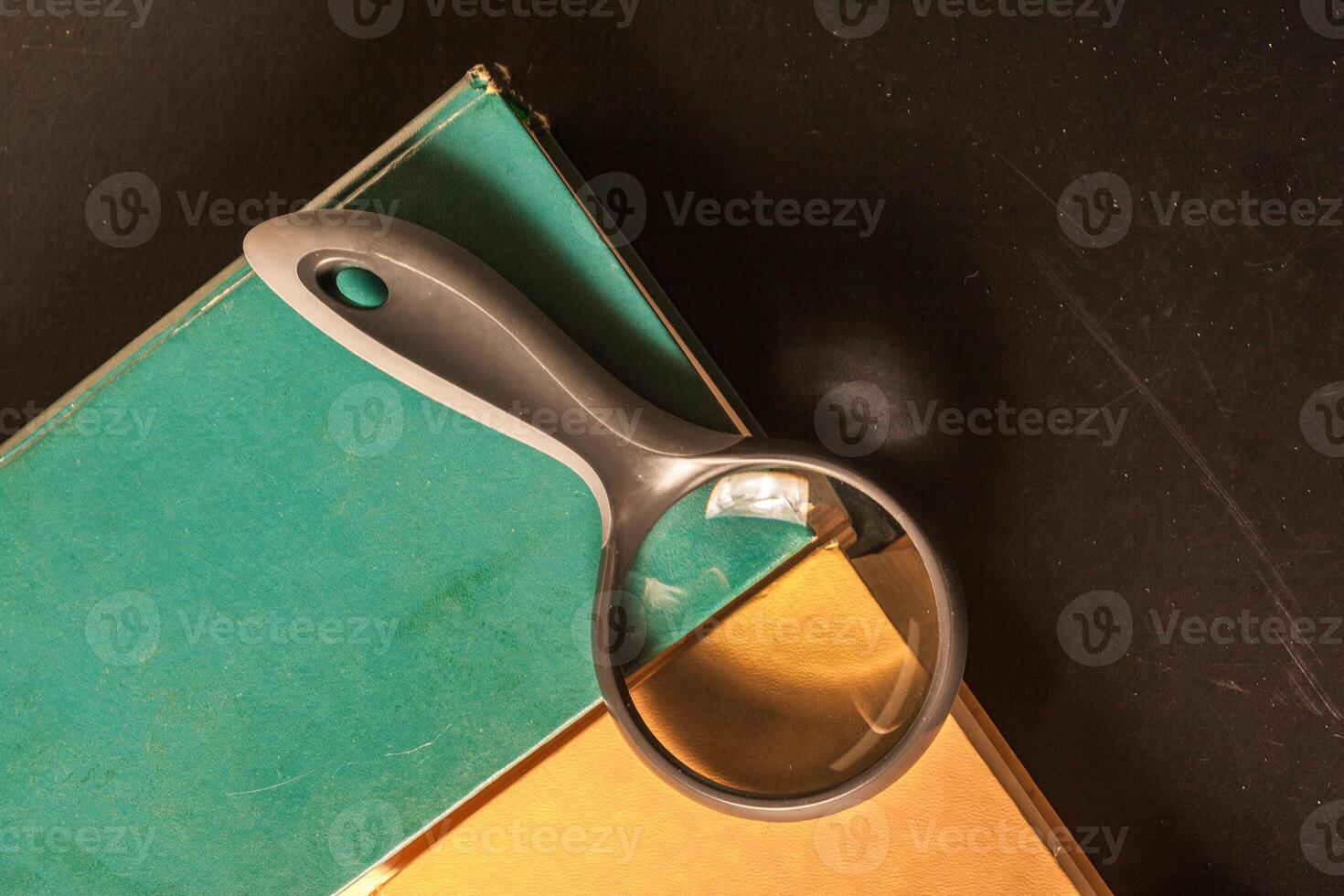 books and magnifying glass photo