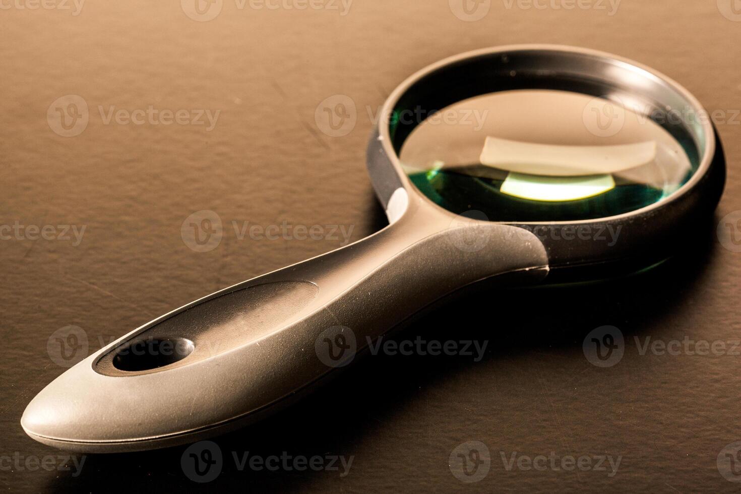 Closeup of magnifying glass on dark surface photo