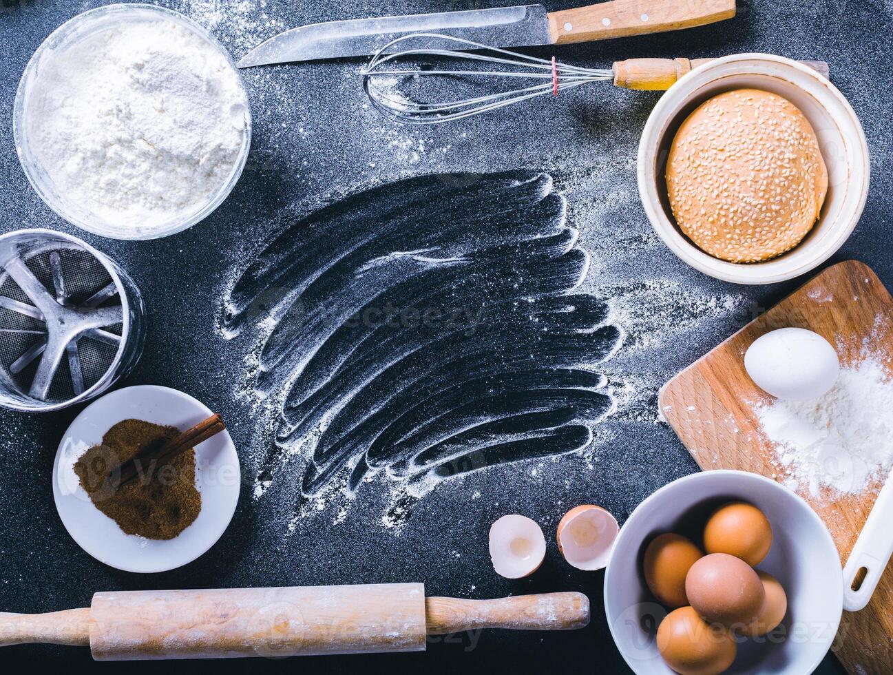 Baking dark background with blank cook book, eggshell, bread, flour, rolling pin. Ingredients for the baking. photo