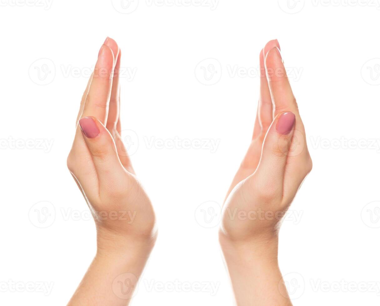 Hands positioned symmetrically against a plain background showing a delicate gesture of greeting or blessing photo