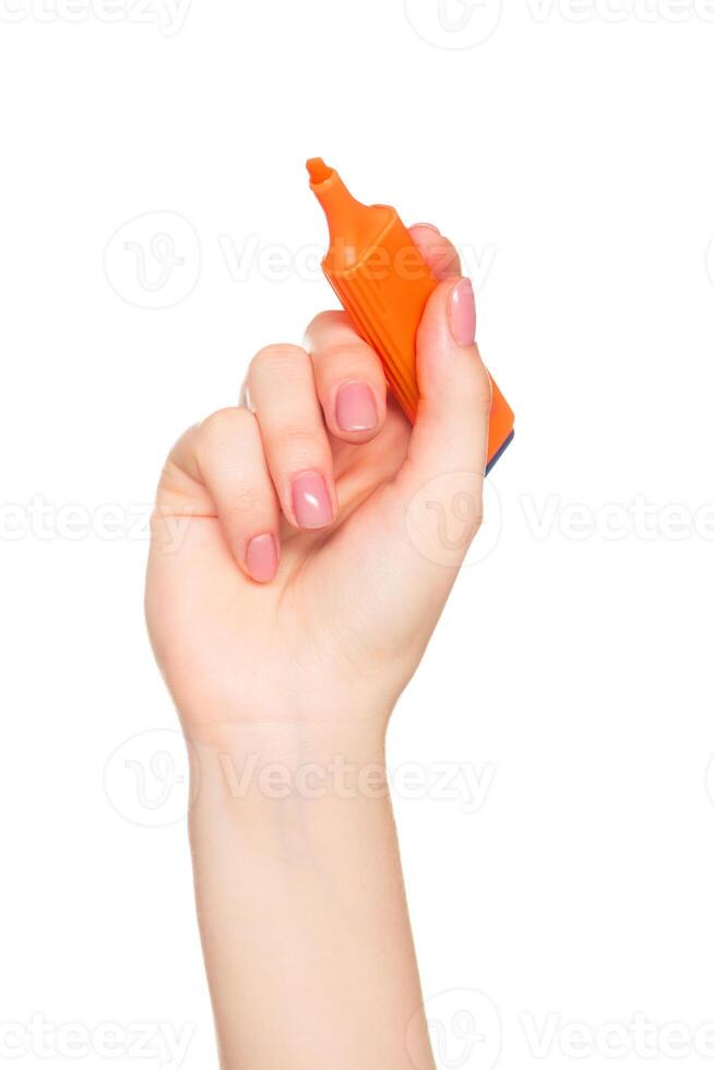 Bright orange highlighter held by hand with perfectly manicured nails against a white background ideal for school or office use photo