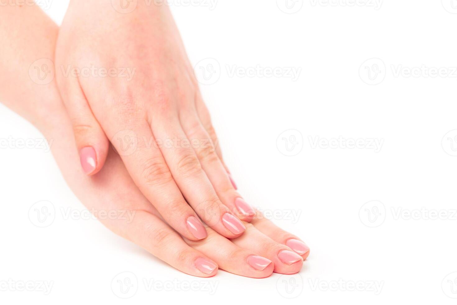 Elegant hands with manicured nails resting gently on each other in a soft, light atmosphere photo