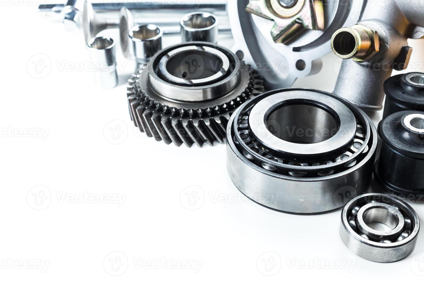 Collection of automotive parts displayed on a clean surface showcasing gears, bearings, and various mechanical components photo