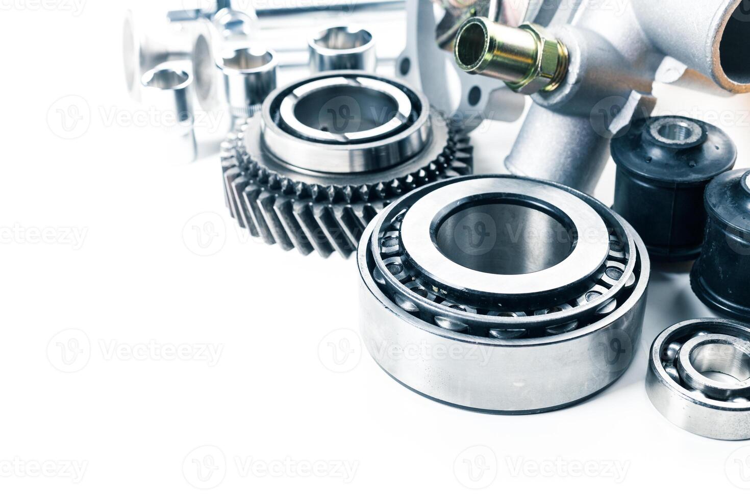 Close-up of various mechanical components including gears, bearings, and fasteners on a workbench in a workshop setting photo