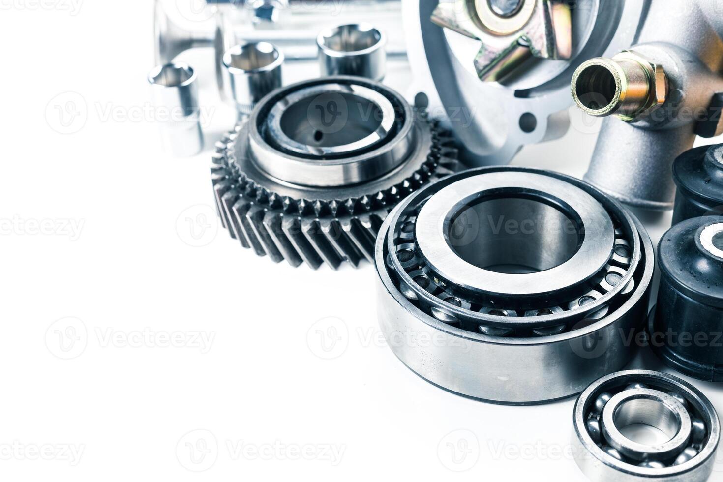 Collection of automotive parts displayed on a clean surface showcasing gears, bearings, and various mechanical components photo
