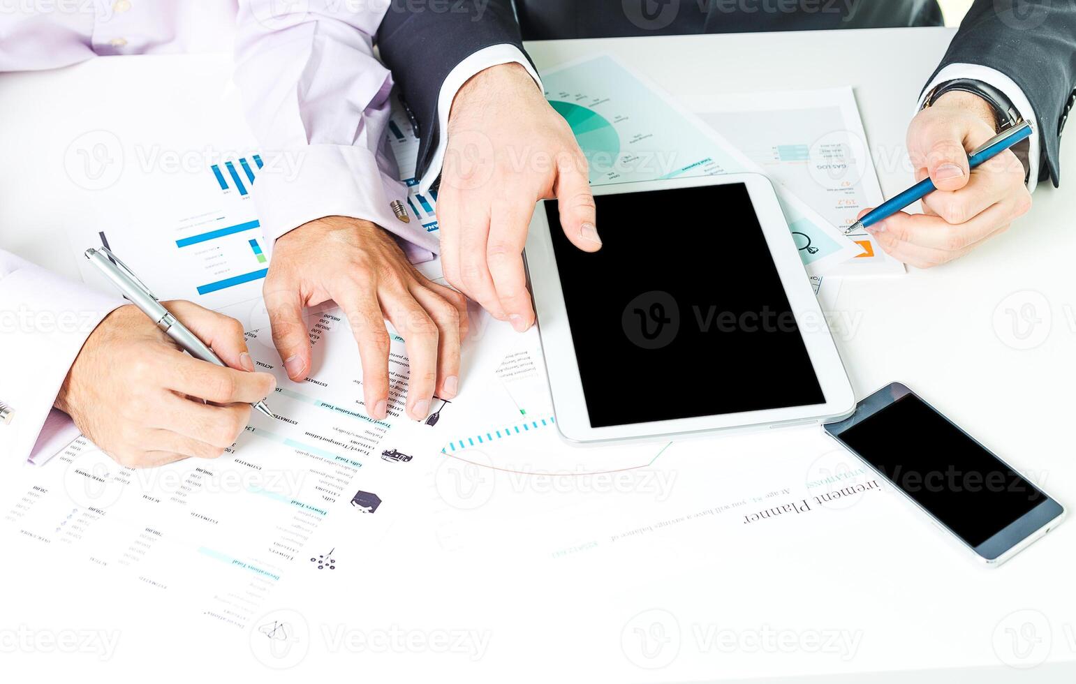 Collaboration among professionals using digital devices and documents at a modern workspace photo