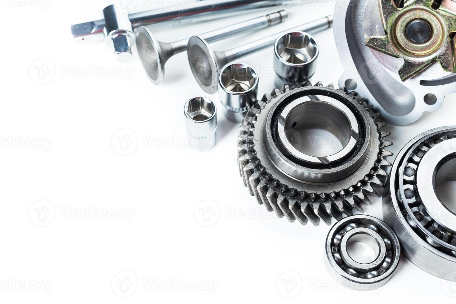 Various metallic components and tools arranged on a white surface for automotive or mechanical use photo