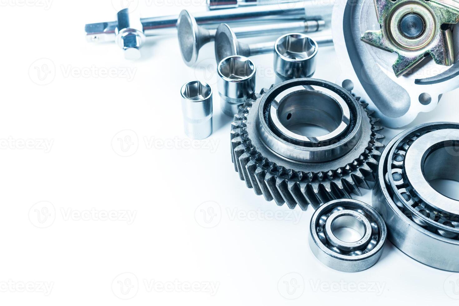 Close-up of various mechanical components including gears and bearings on a clean white background photo