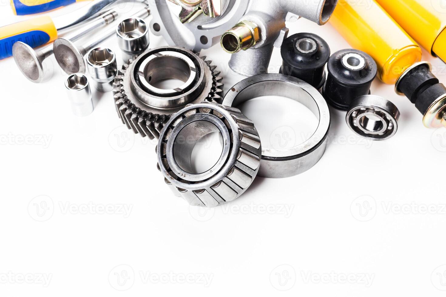 Various mechanical parts and tools for automotive repair displayed on a clean surface photo