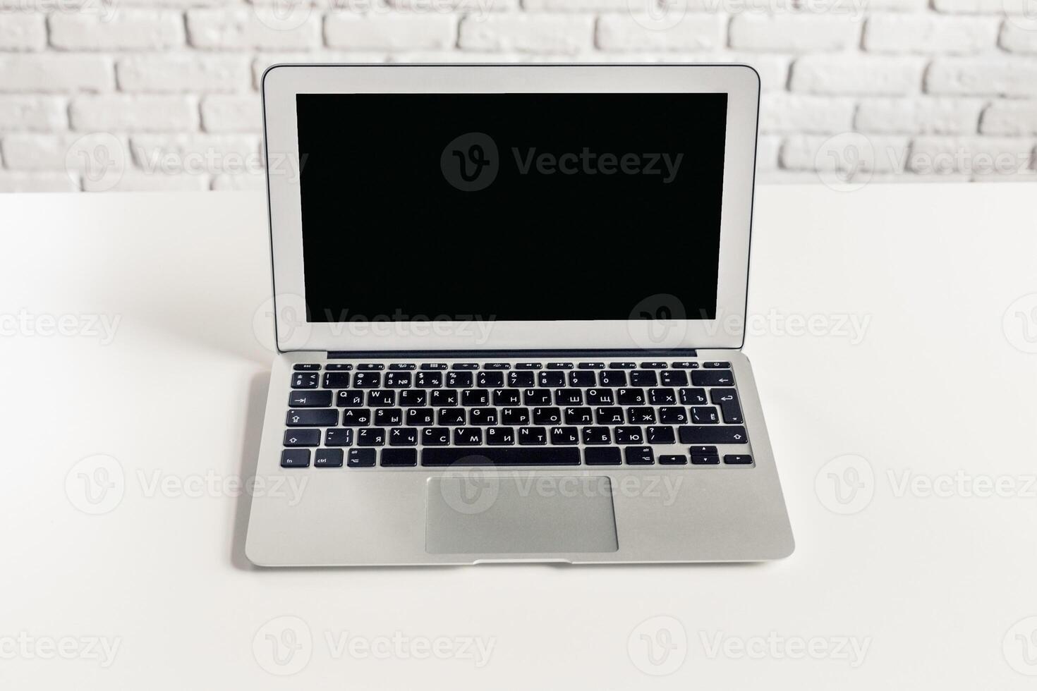 Laptop on a clean white desk with a minimalistic background in a bright room photo