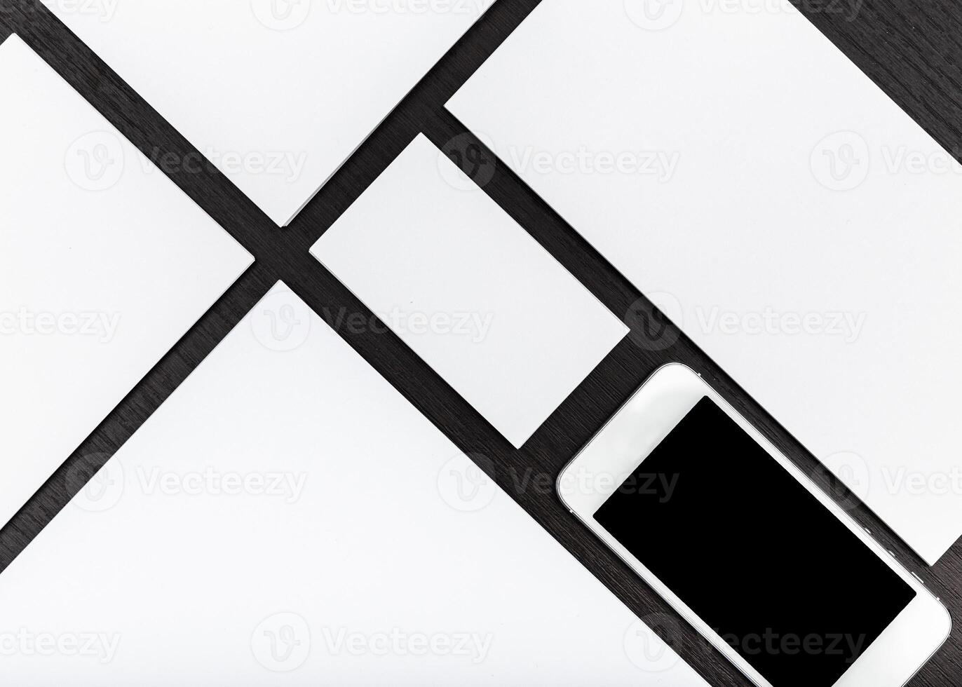 Modern workspace with smartphone and blank stationery on wooden background photo