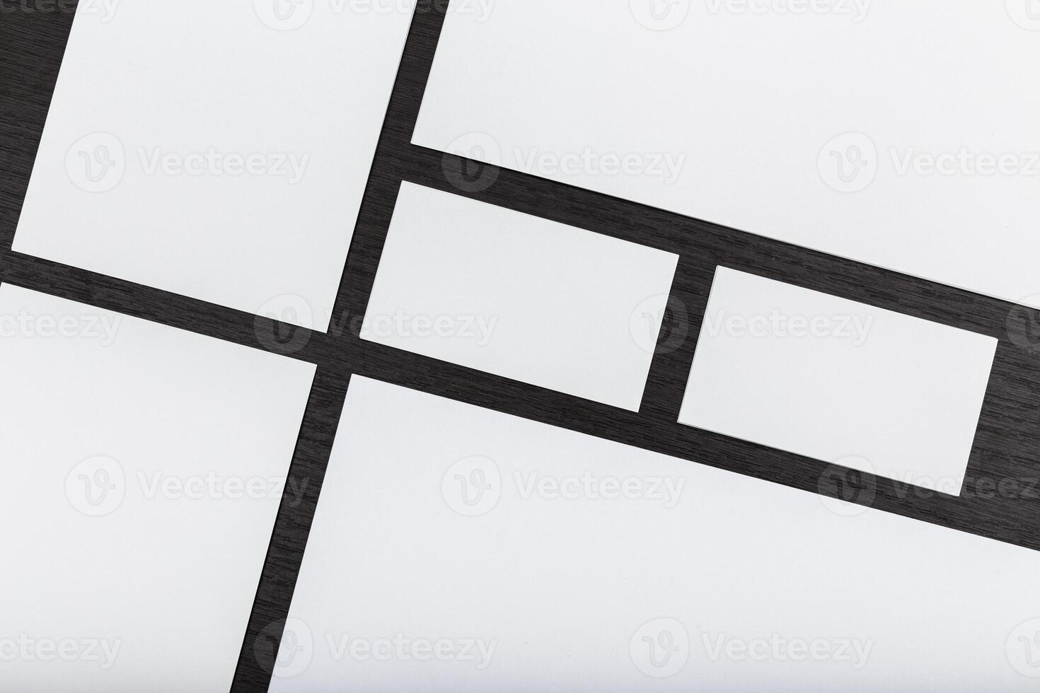 Unique layout of blank paper sheets arranged on a dark wooden surface for design or planning purposes photo