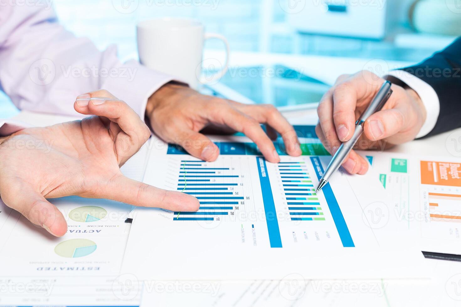 Business partners collaborating on financial reports and analysis during a meeting photo
