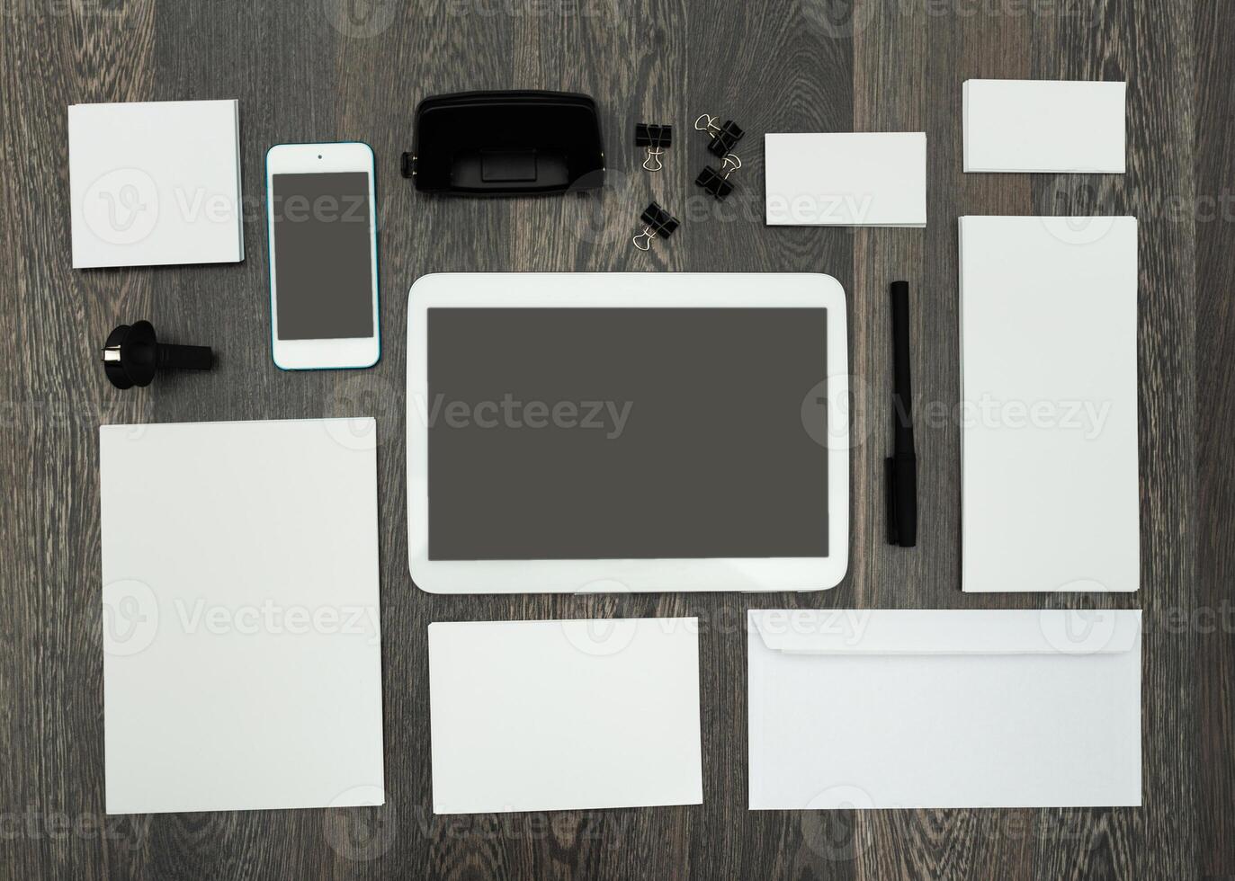 Office workspace layout with digital devices and stationery materials in a minimalistic arrangement photo