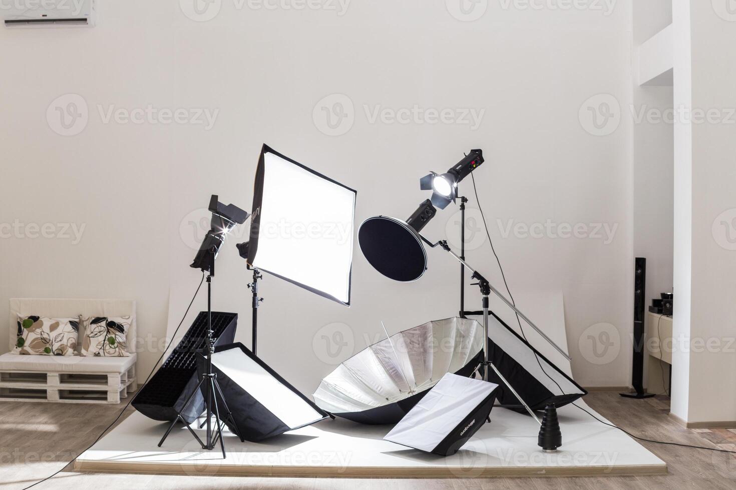 Professional photography studio setup featuring lighting equipment and reflectors in a spacious indoor environment photo