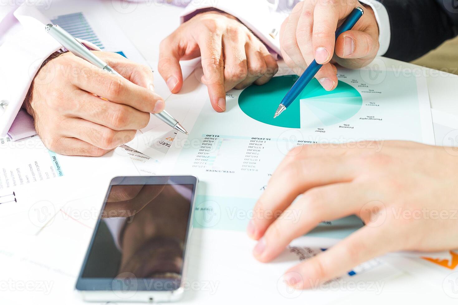Business professionals collaborating on financial analysis and strategy development at an office setting photo