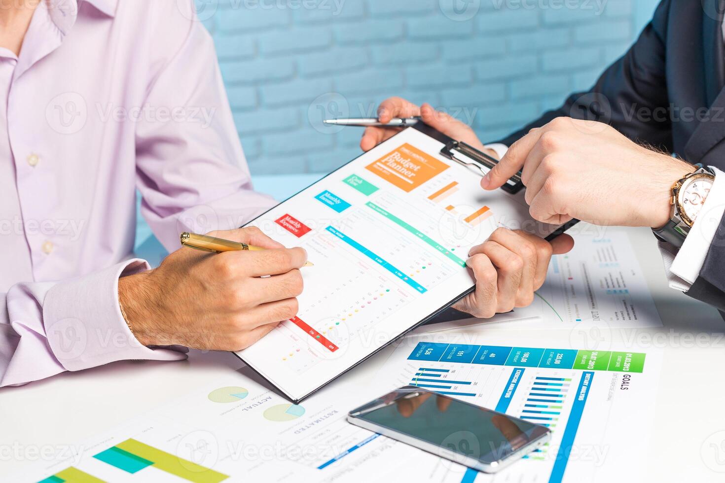 Business professionals discussing financial reports at a meeting table using charts and graphs to analyze performance data photo