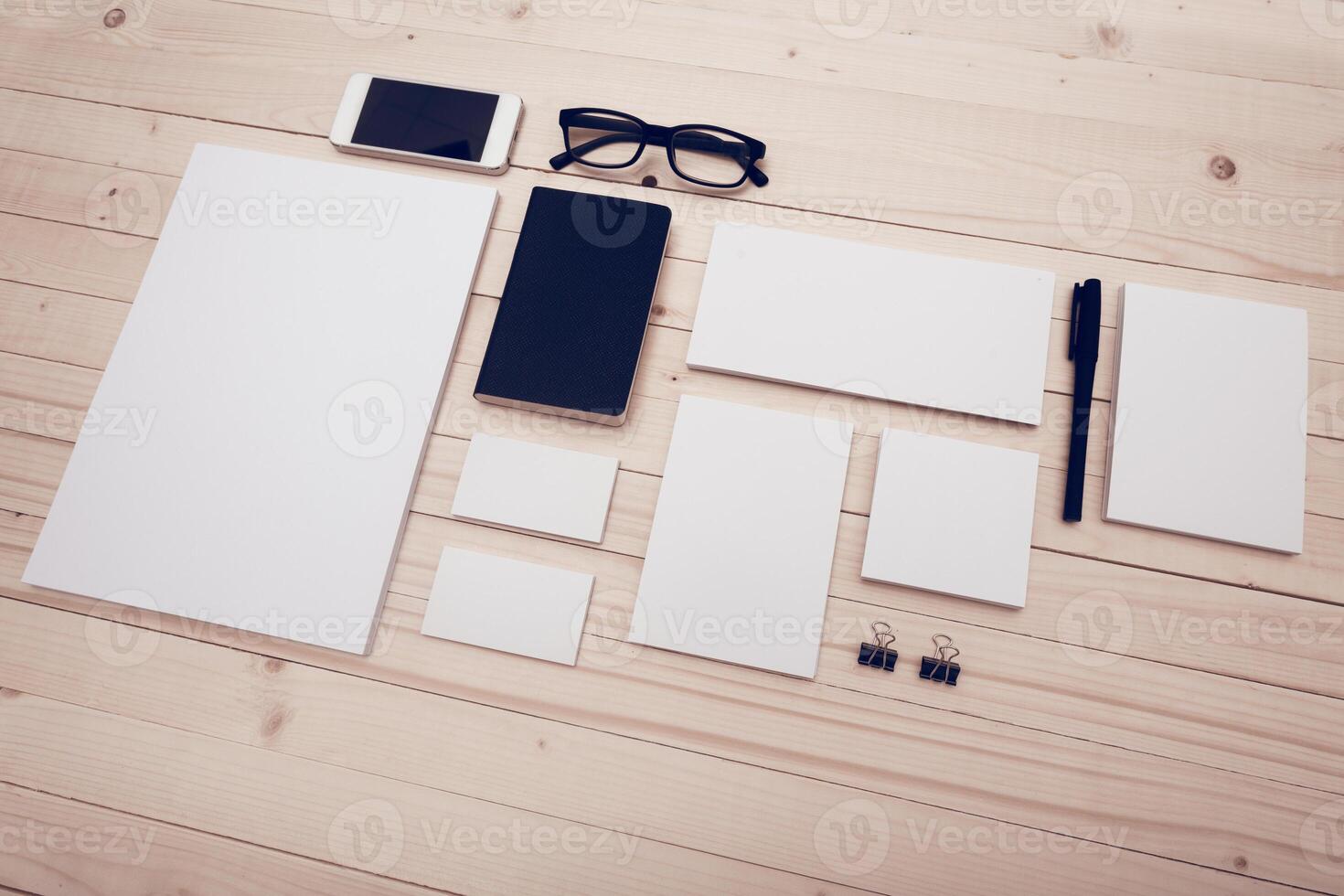 Office workspace setup with stationery and digital devices on wooden table photo