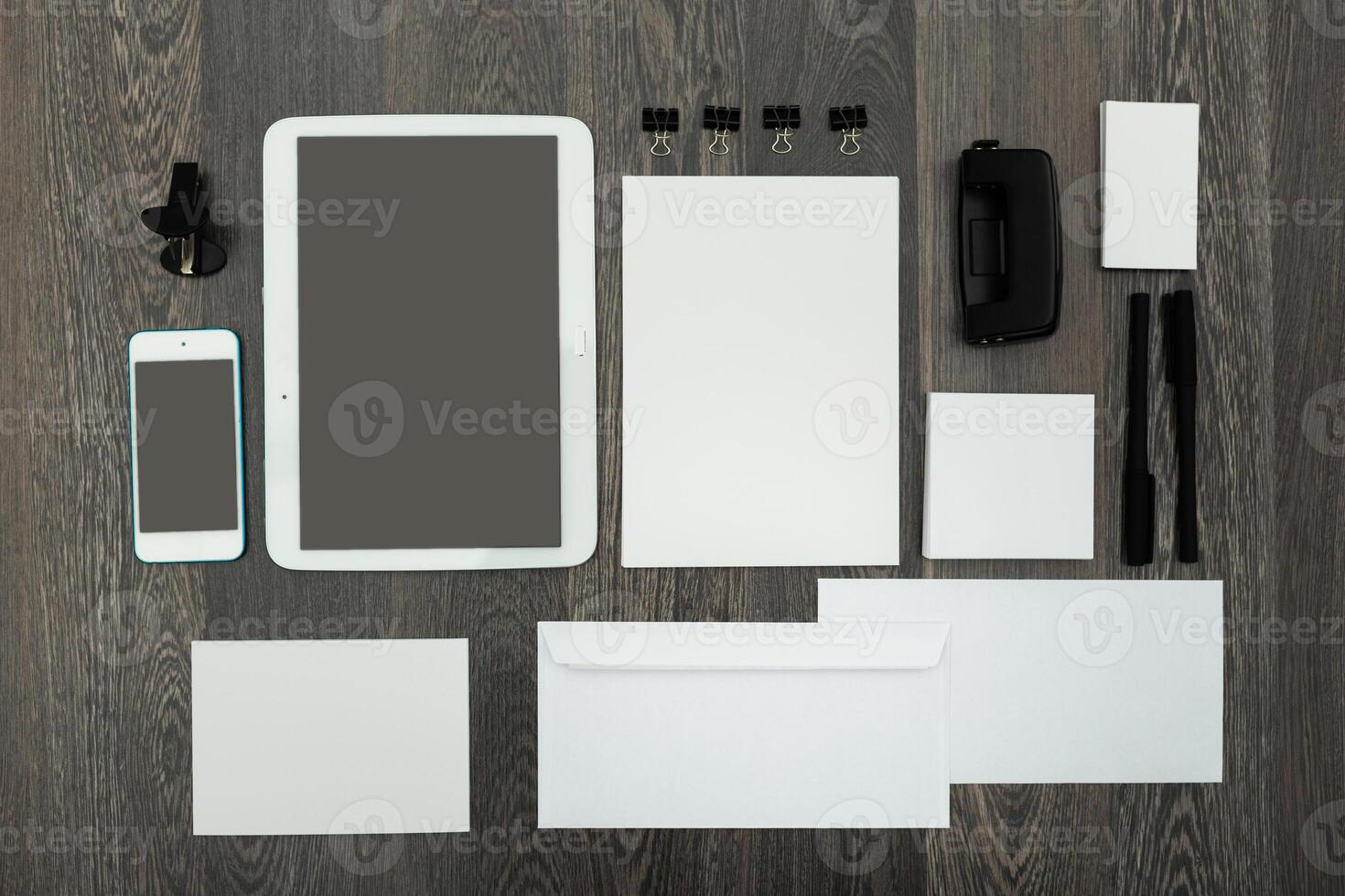 Organized workspace layout featuring digital and stationary tools on wooden background photo