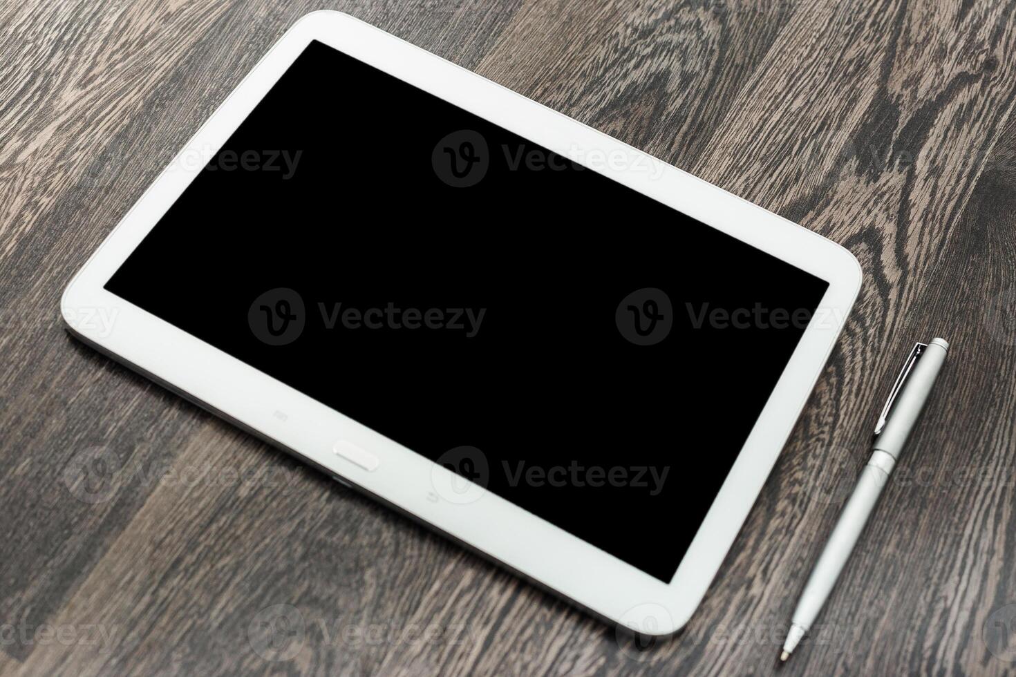 Tablet and pen placed on wooden surface ready for use in creative or professional tasks photo