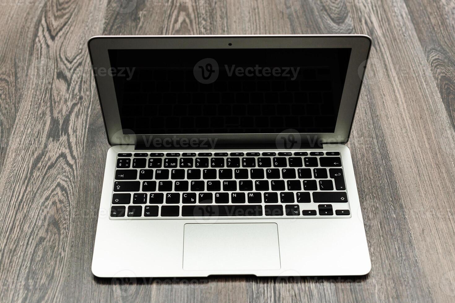 Laptop placed on wooden surface, ready for use or showcasing its sleek design in a modern workspace setting photo