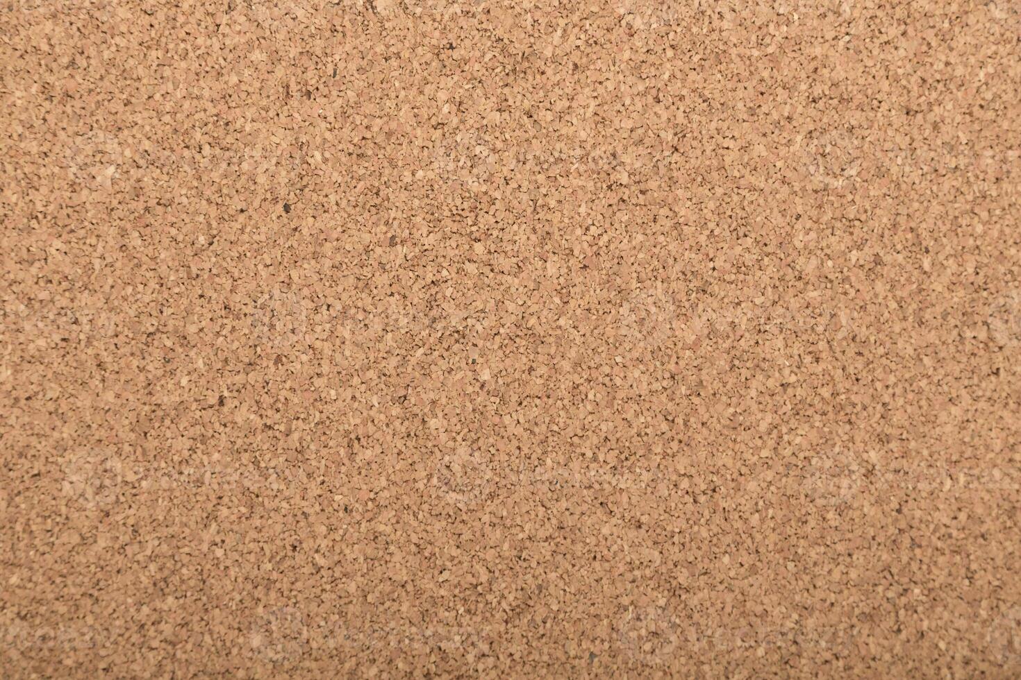 Cork board surface showing a simple and natural texture suitable for notes and messages photo
