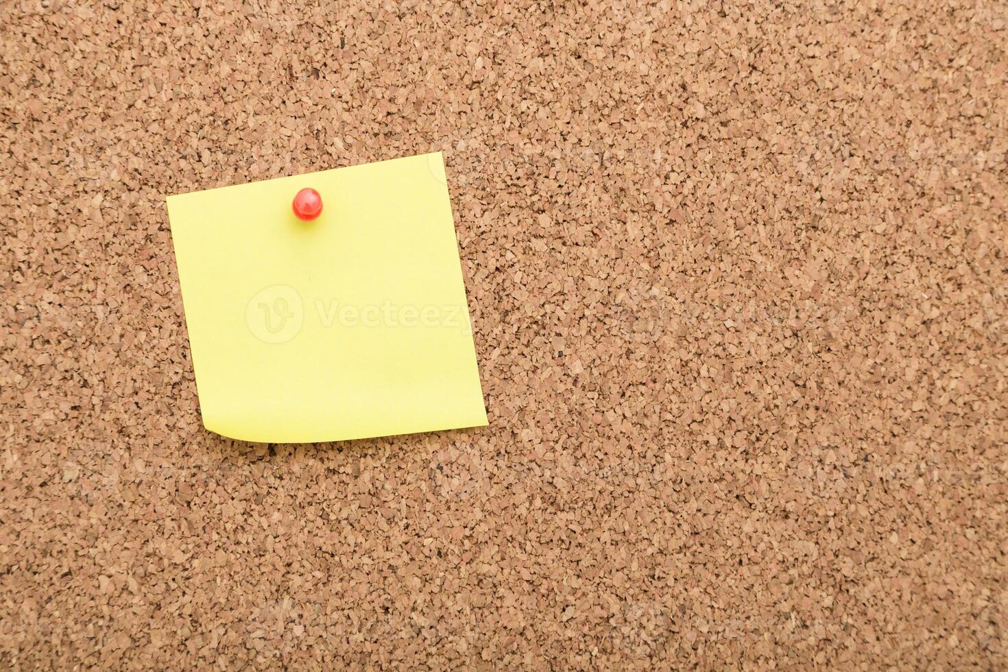 Sticky note pinned on a corkboard in an office setting during daytime photo