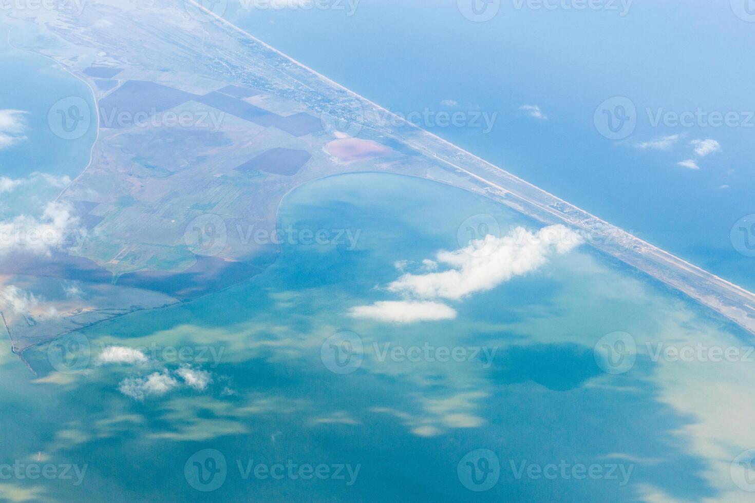 Coastal landscape with water, clouds, and road seen from above on a clear day photo