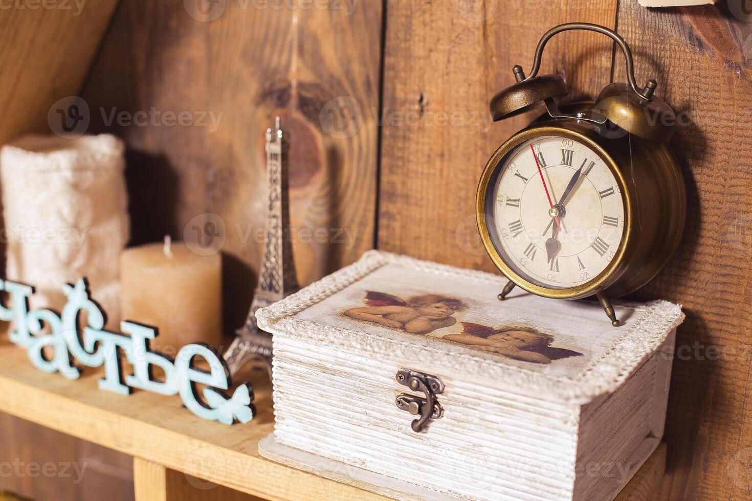 Vintage decor with wooden shelf, antique clock, and decorative items in cozy setting photo
