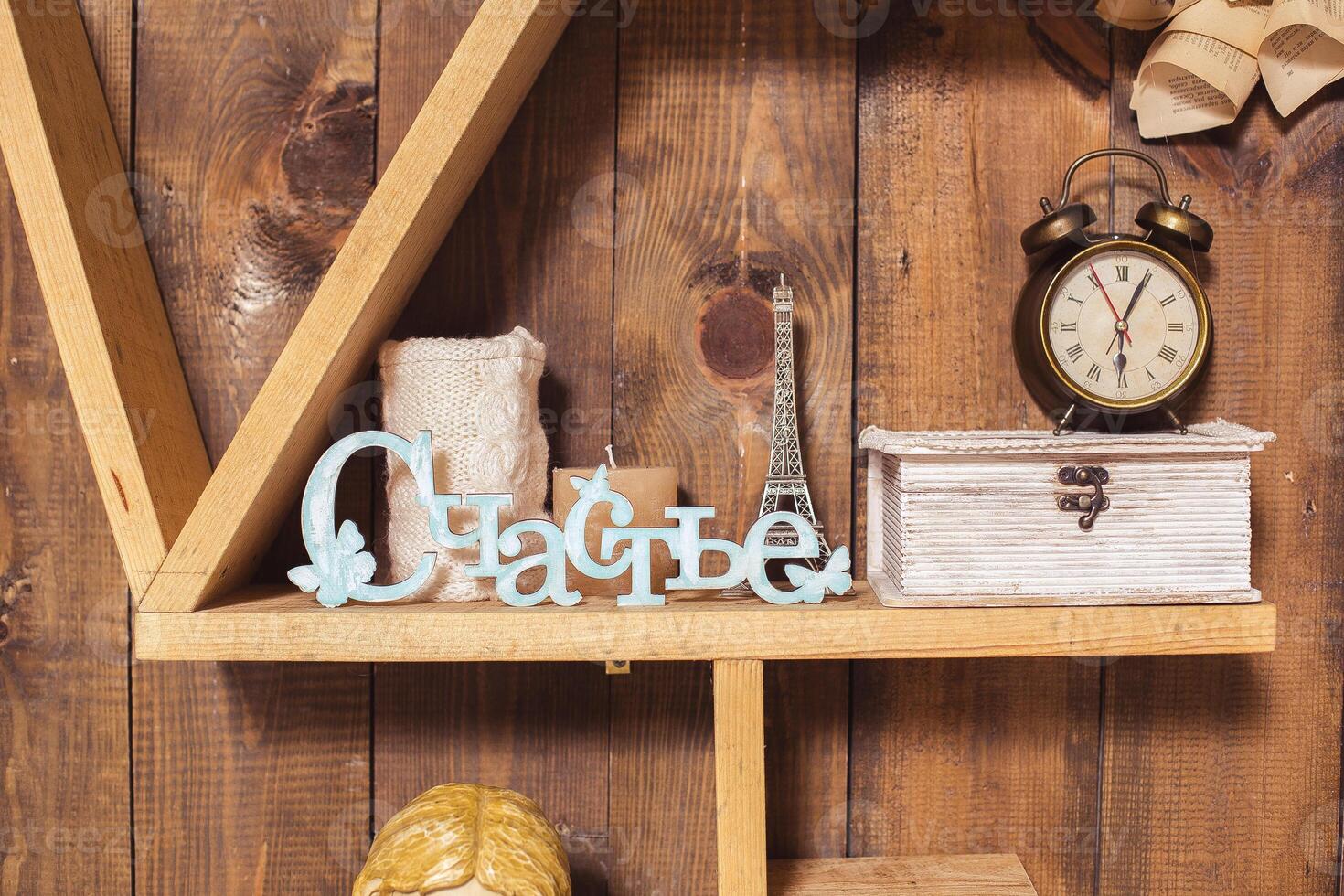 Decorative wooden shelf displaying various items such as a clock, small Eiffel Tower, and a decorative sign representing happiness photo
