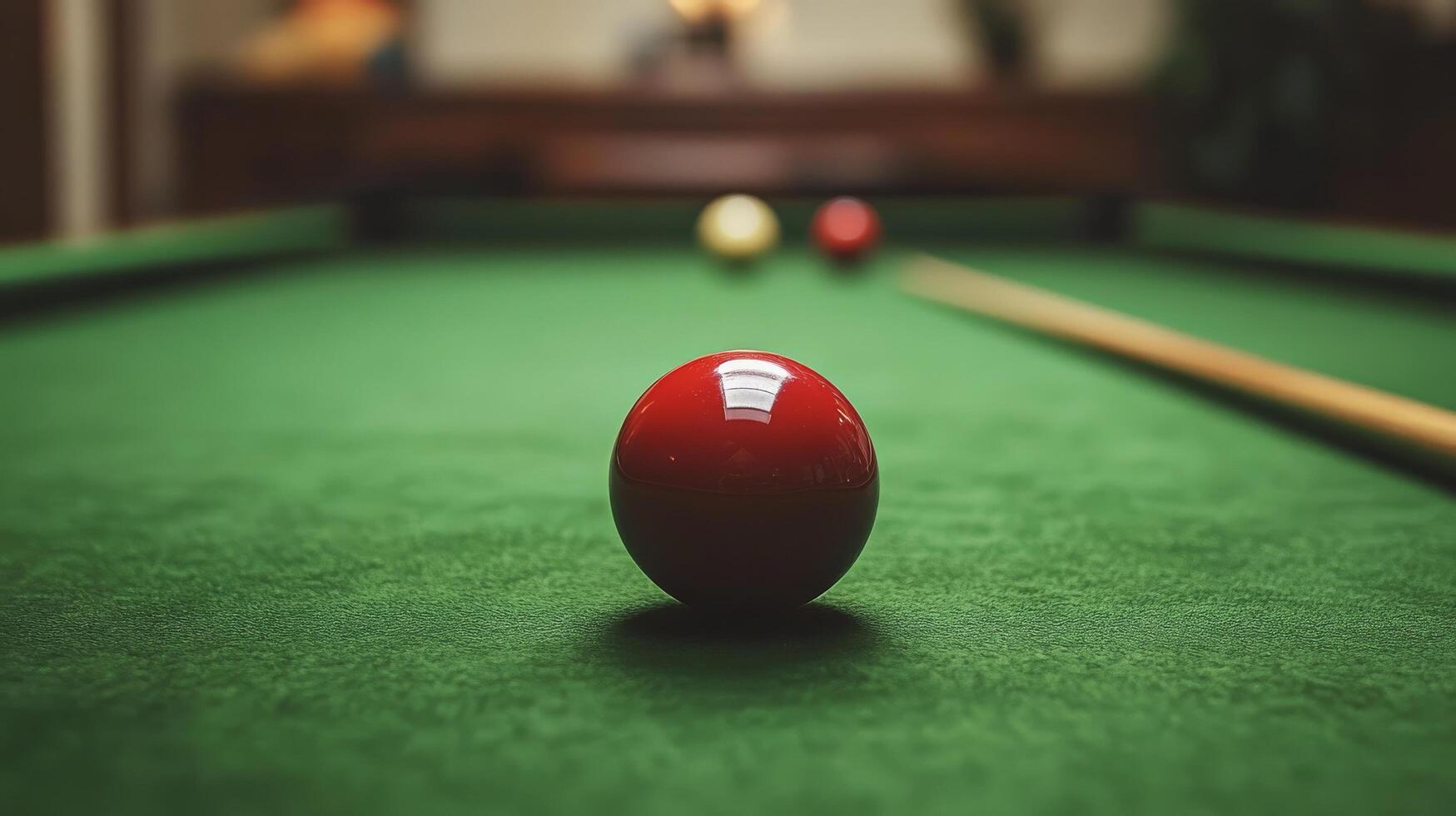 A red ball sits on a pool table photo