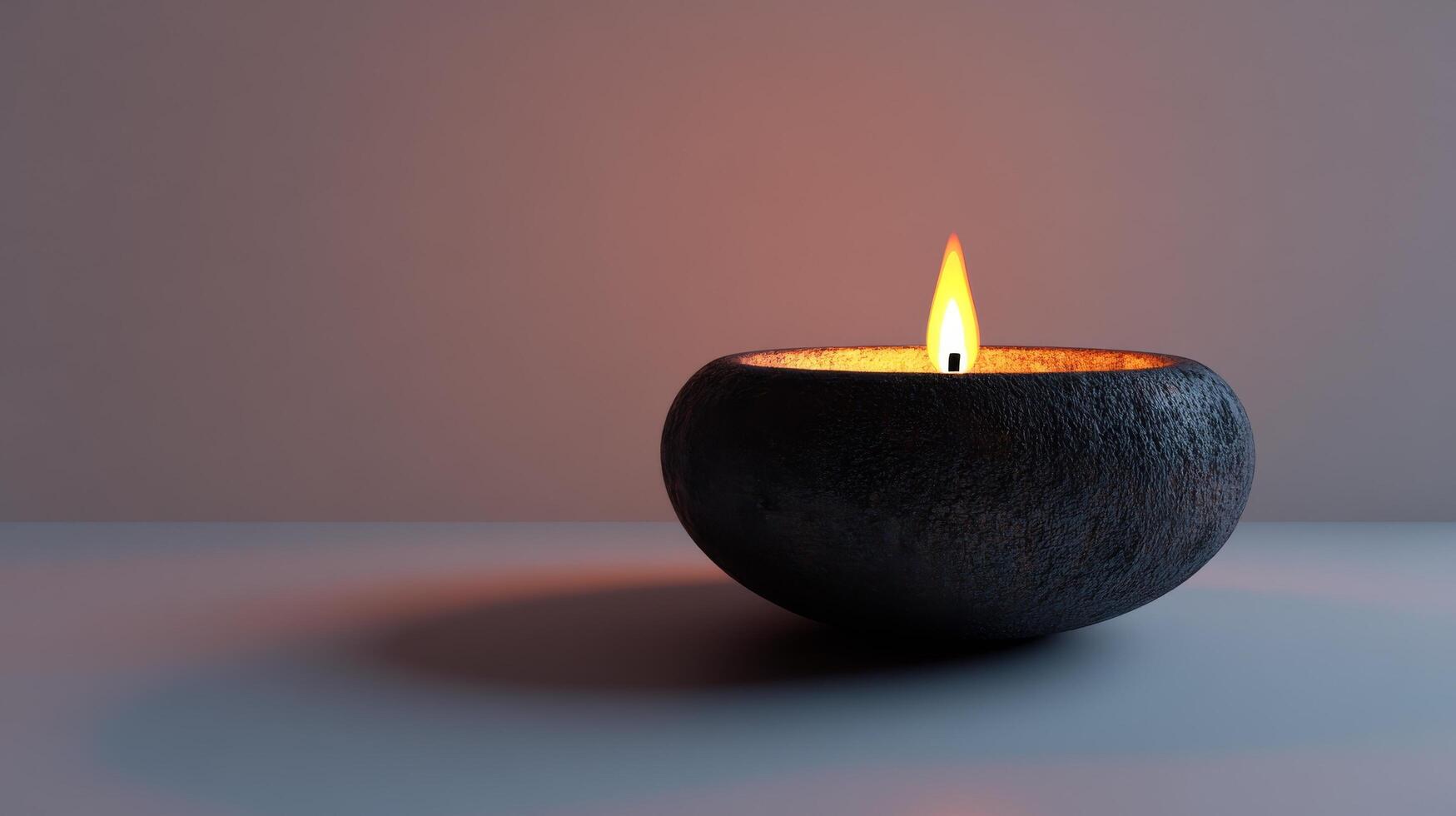A black candle is lit in a small black bowl photo