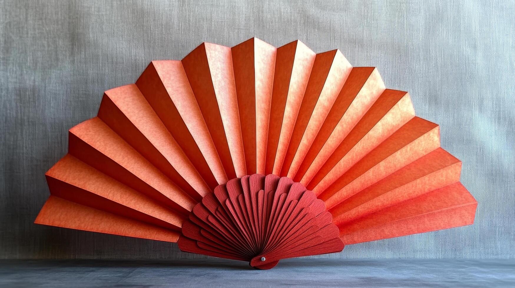 A fan made of orange paper with a red center photo