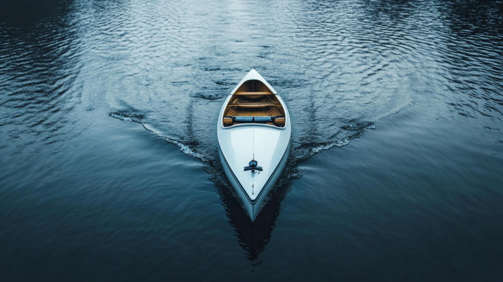 Serene canoe gliding over calm lake waters at dusk with gentle ripples surrounding photo