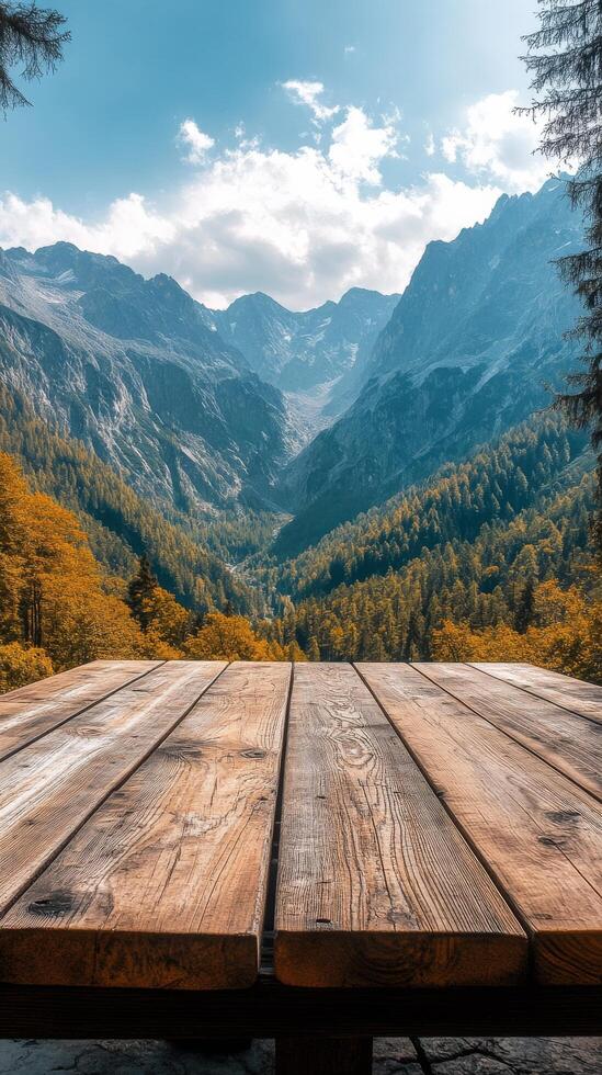An empty wooden table in front of a mountain range photo