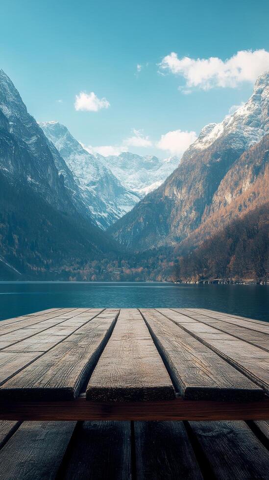 A wooden deck overlooking a lake and mountains photo