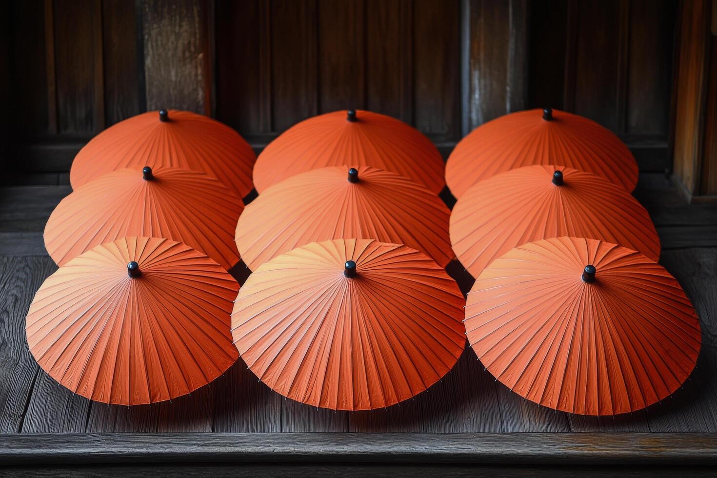 A group of eight orange umbrellas sitting on a wooden table photo
