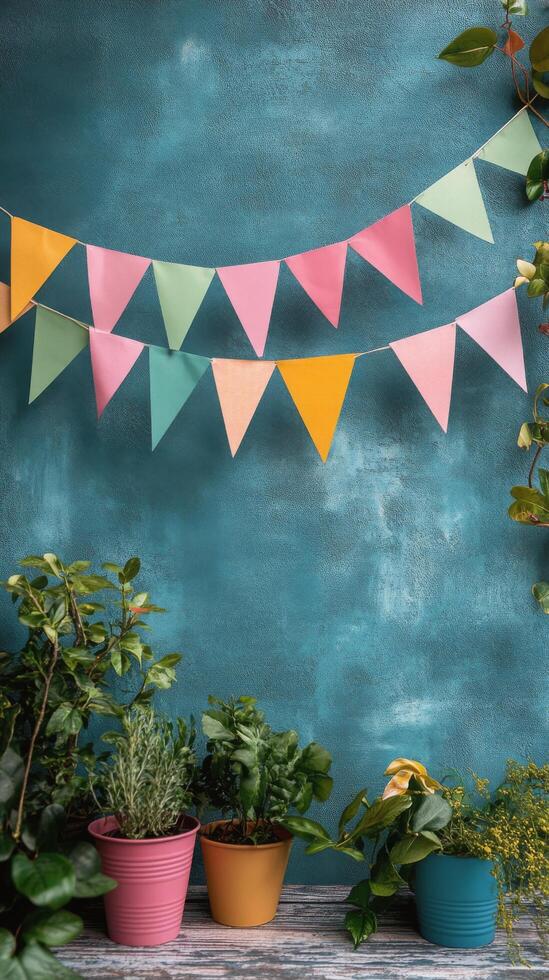 Colorful bunting and potted plants on a blue wall photo