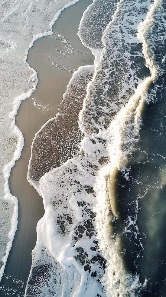 Aerial view of waves crashing on the beach photo