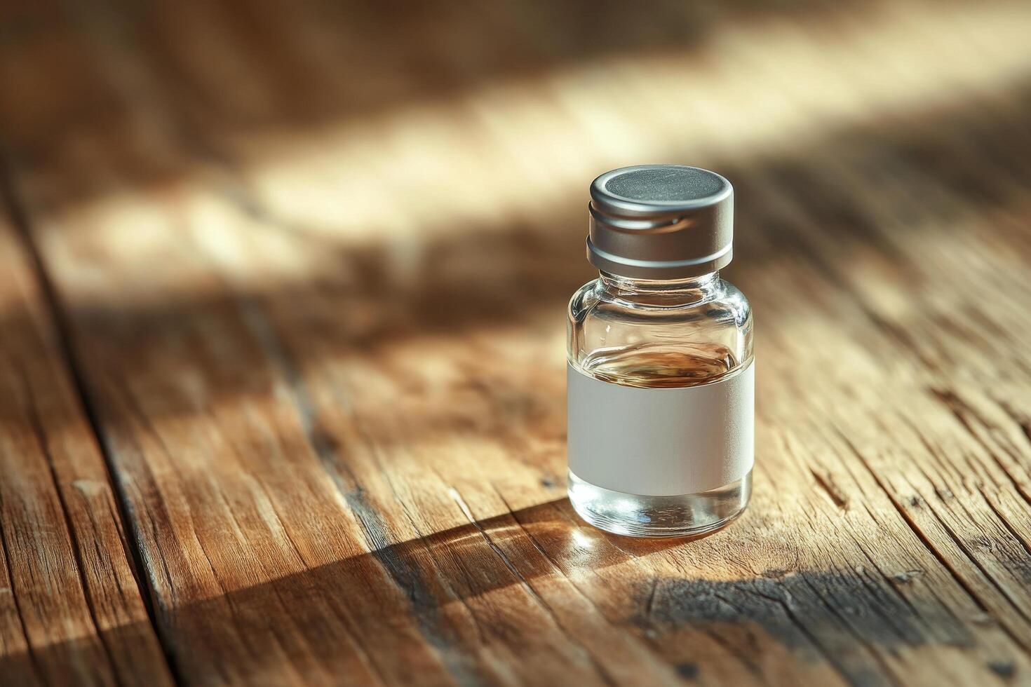 A small bottle of alcohol sitting on a wooden table photo
