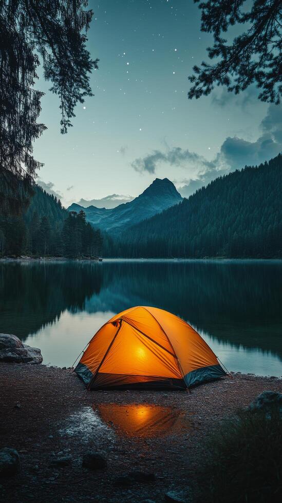Camping tent on the shore of a lake at night photo